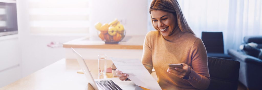 Post hero image of a woman holding a piece of paper and a phone