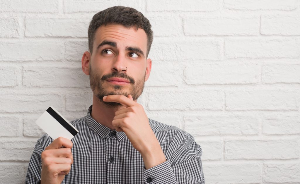 Persona que sostiene una tarjeta de crédito con consideración.